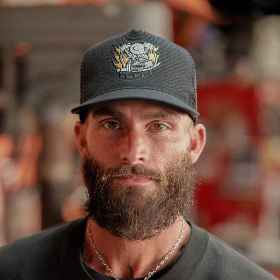 Man wearing a black cap and dark shirt with a blurred background
